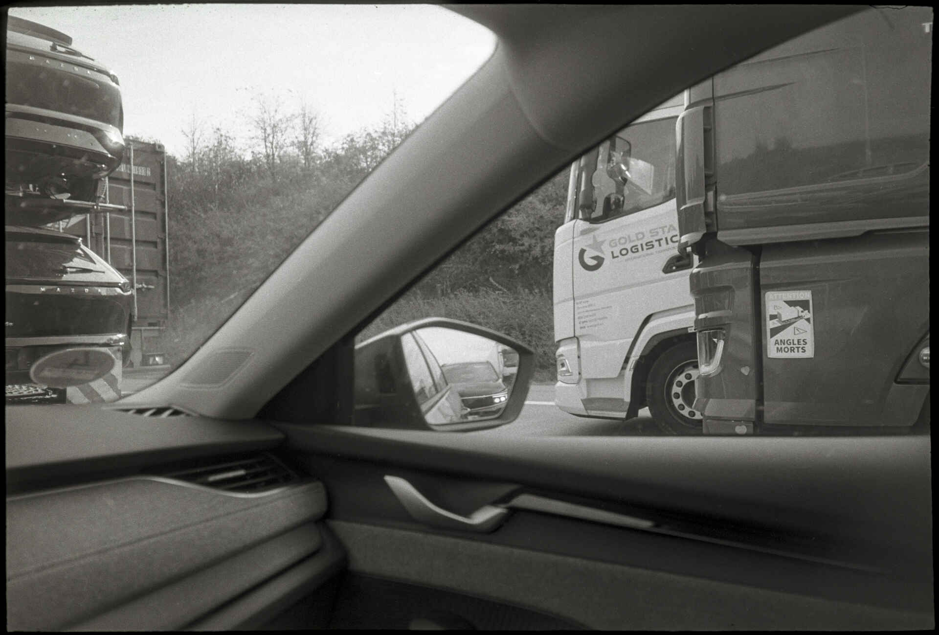 Autobahn A1 bei Bramsche (Foto: Martin Frech, 9/2026) Schwarzweißbild (digitalisiert vom Kodak-Tri-X-Kleinbild-Negativ): Blick aus dem im Stau stehenden Pkw auf der Autobahn A1 bei Bramsche auf Lkws auf den anderen Spuren.