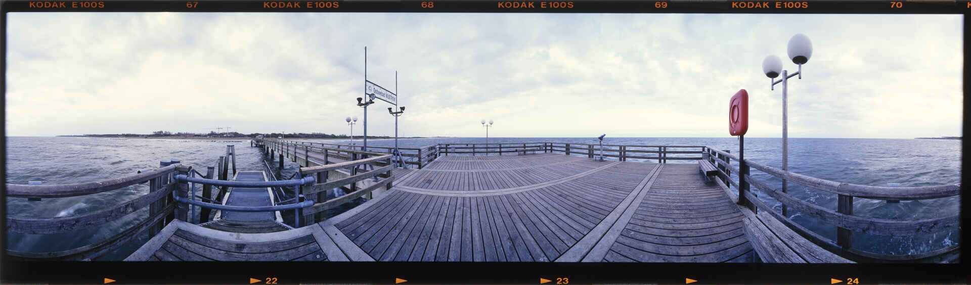 Rundblick von der Seebrücke Wustrow in der Ostsee (mit noch funktionierendem Schiffsanleger, aber auch noch ohne Leuchttürmchen). (Foto: Martin Frech, 10/2000) Farbfoto: Panoramablick auf der Seebrücke Ostseebad Wustrow. (Foto: Martin Frech, 10/2000)