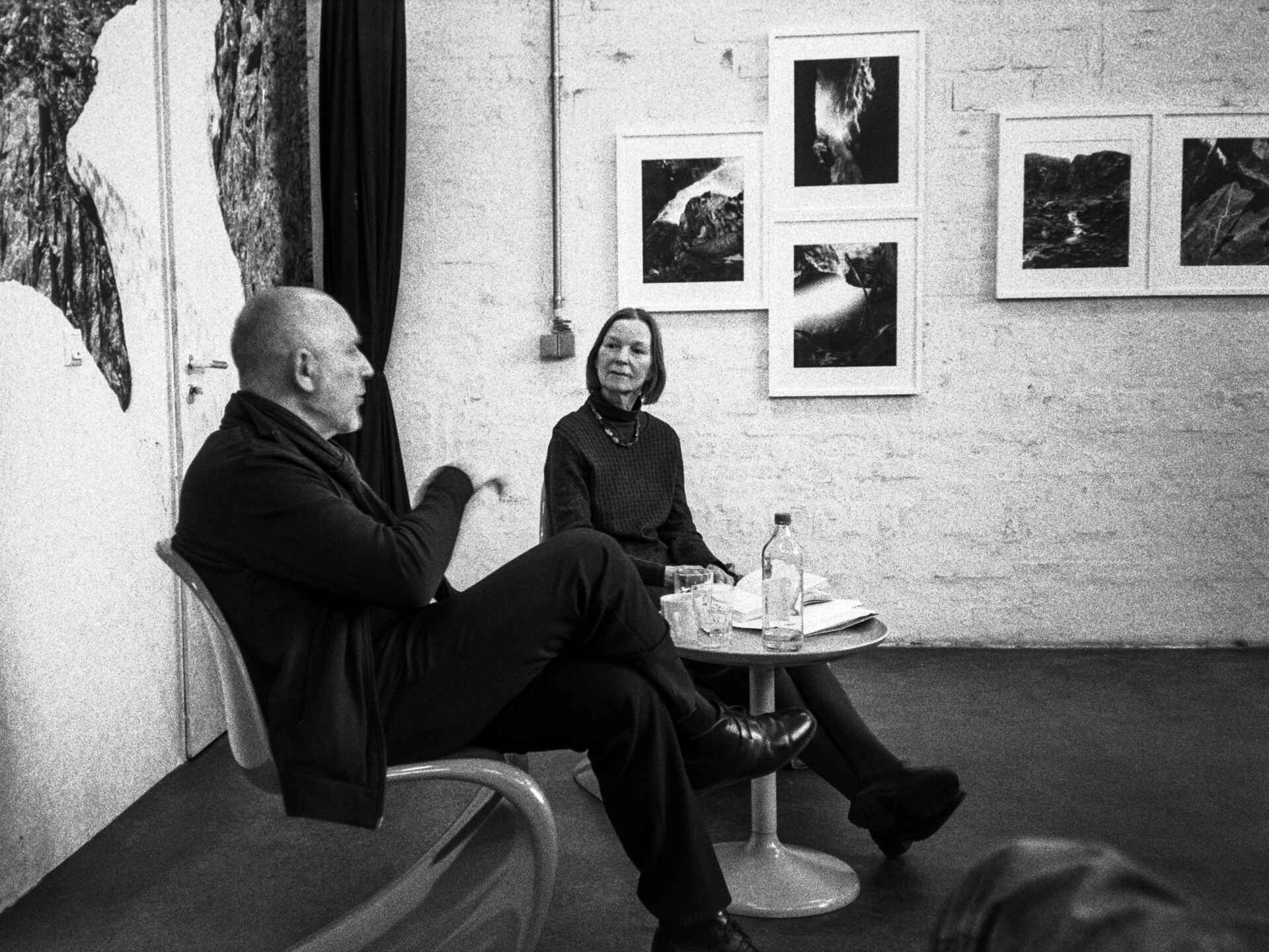 Schwarzweißbild (Digitalisat vom Kleinbildnegativ): Dr. Jutta Höfel und Tobias D. Kern im Gespräch (schaelpic photokunstbar, Köln). (Foto: Martin Frech, 3/2026)