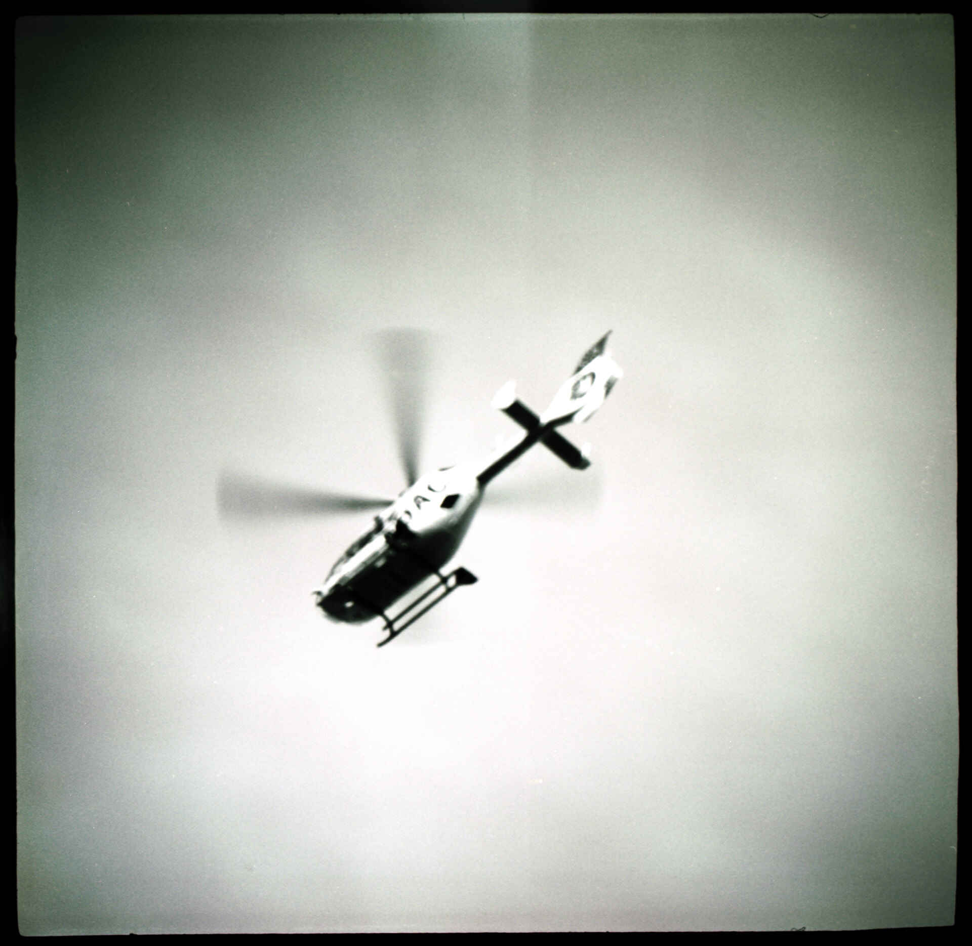 Rettungshubschrauber in Berlin (Foto: Martin Frech, 6/2009) Schwarzweißbild: Ein Rettungshubschrauber in der Luft vom Boden aus gesehen. (Foto: Martin Frech, 6/2009)