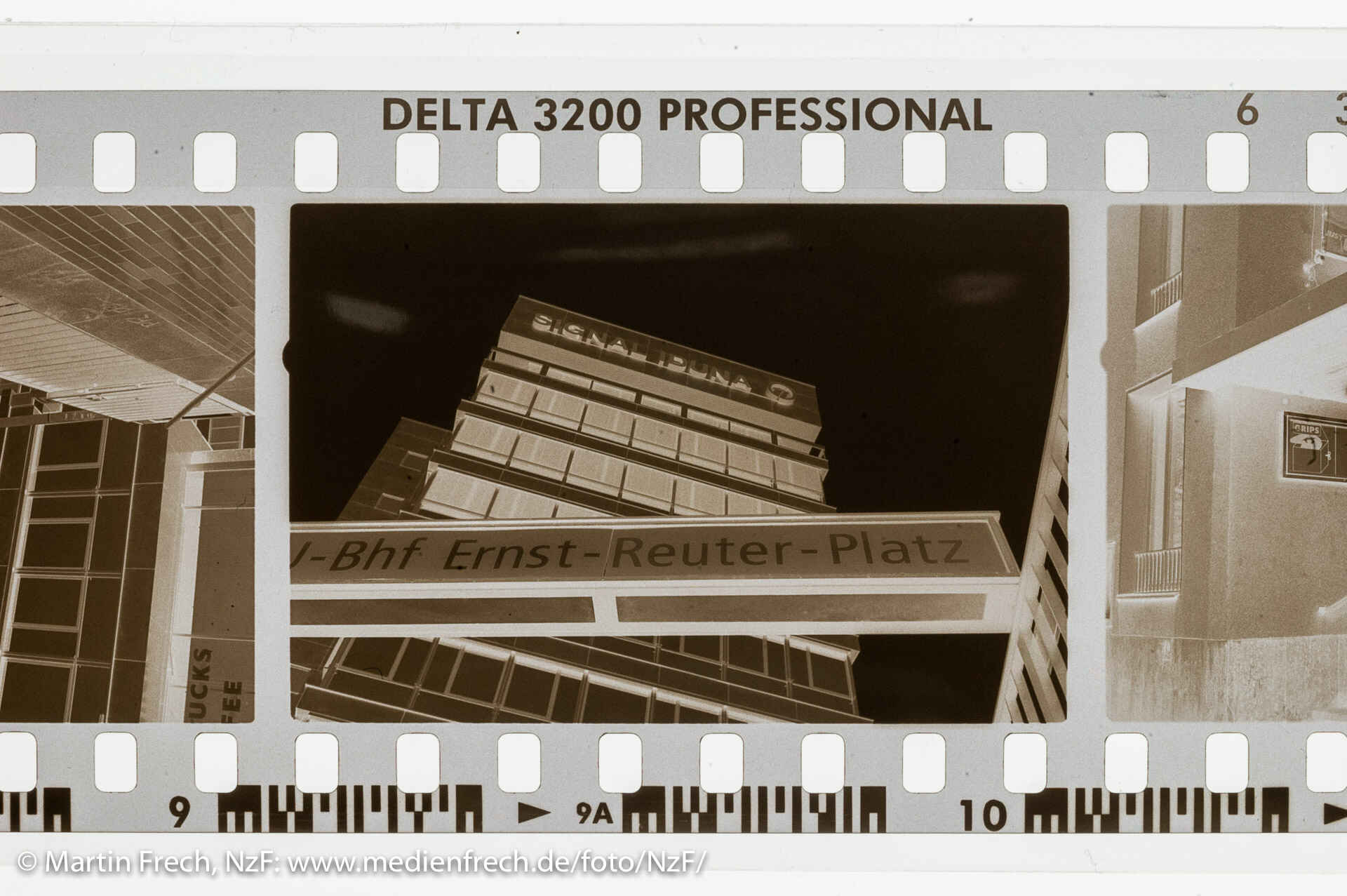 Ilford Delta 3200, entwickelt in Tanol (Foto: Martin Frech, 12/2007) Ein Ausschnitt eines in Tanol entwickelten Negativstreifens Ilford Delta 3200 Prof. auf der Leuchtplatte. Das Negativ zeigt die Sicht auf ein Hochhaus aus dem U-Bahn-Aufgang Ernst-Reuter-Platz (Berlin). (Foto: Martin Frech, 12/2007)