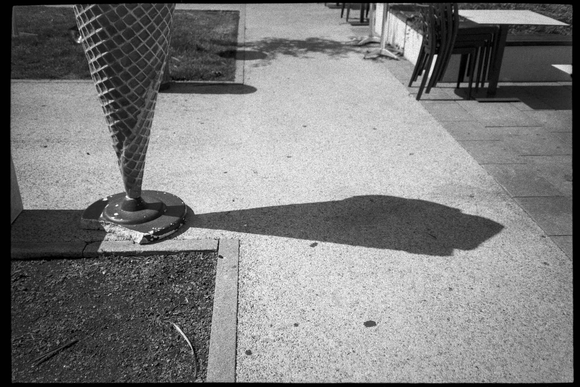 Schwarzweißbild (digitalisiert vom Adox-CHS-II-Kleinbild-Negativ): Unteres Ende einer Werbe-Eistüte mit Schatten des kompletten Objekts.