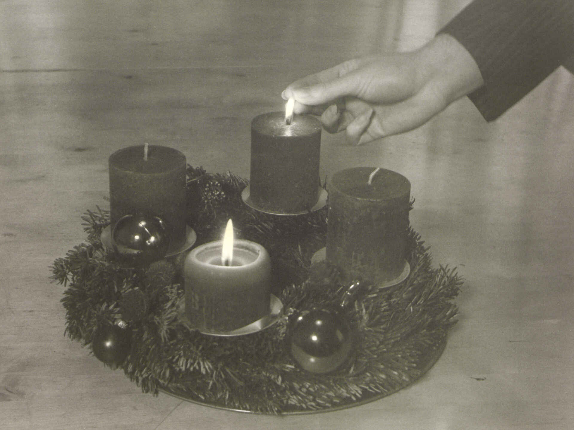 Adventszeit; Kamera: Yashica 44-A (Foto: Martin Frech, 12/2025) Schwarzweißbild (Scan des Baryt-Handabzugs): Die zweite Kerze am Adventskranz wird angezündet (Foto: Martin Frech, 12/2025)
