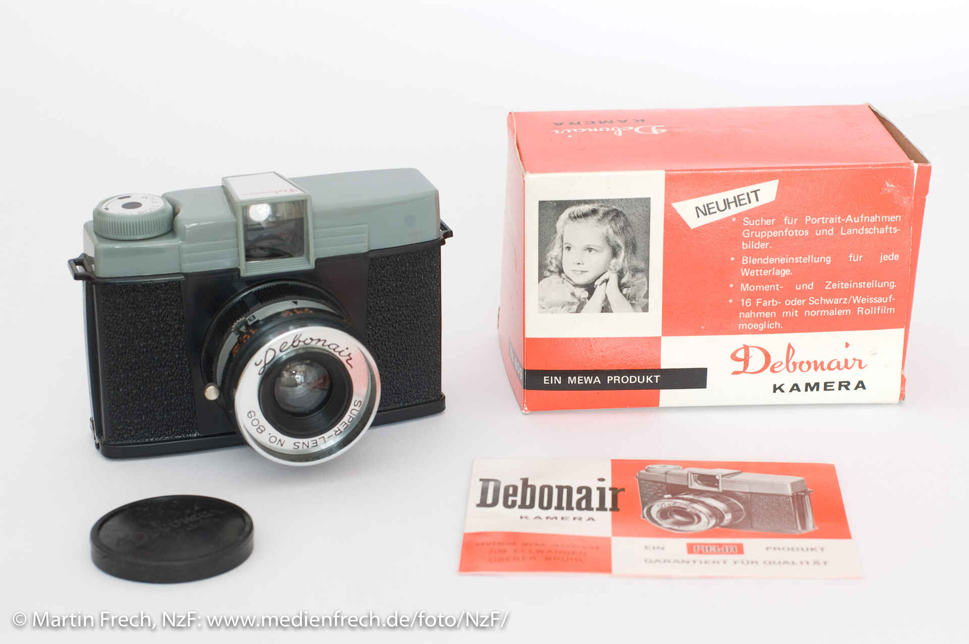 Farbbild: Die Debonair-Kamera mit Objektivdeckel, Bedienungsanleitung und Originalverpackung (Foto: Martin Frech, 7/2009)