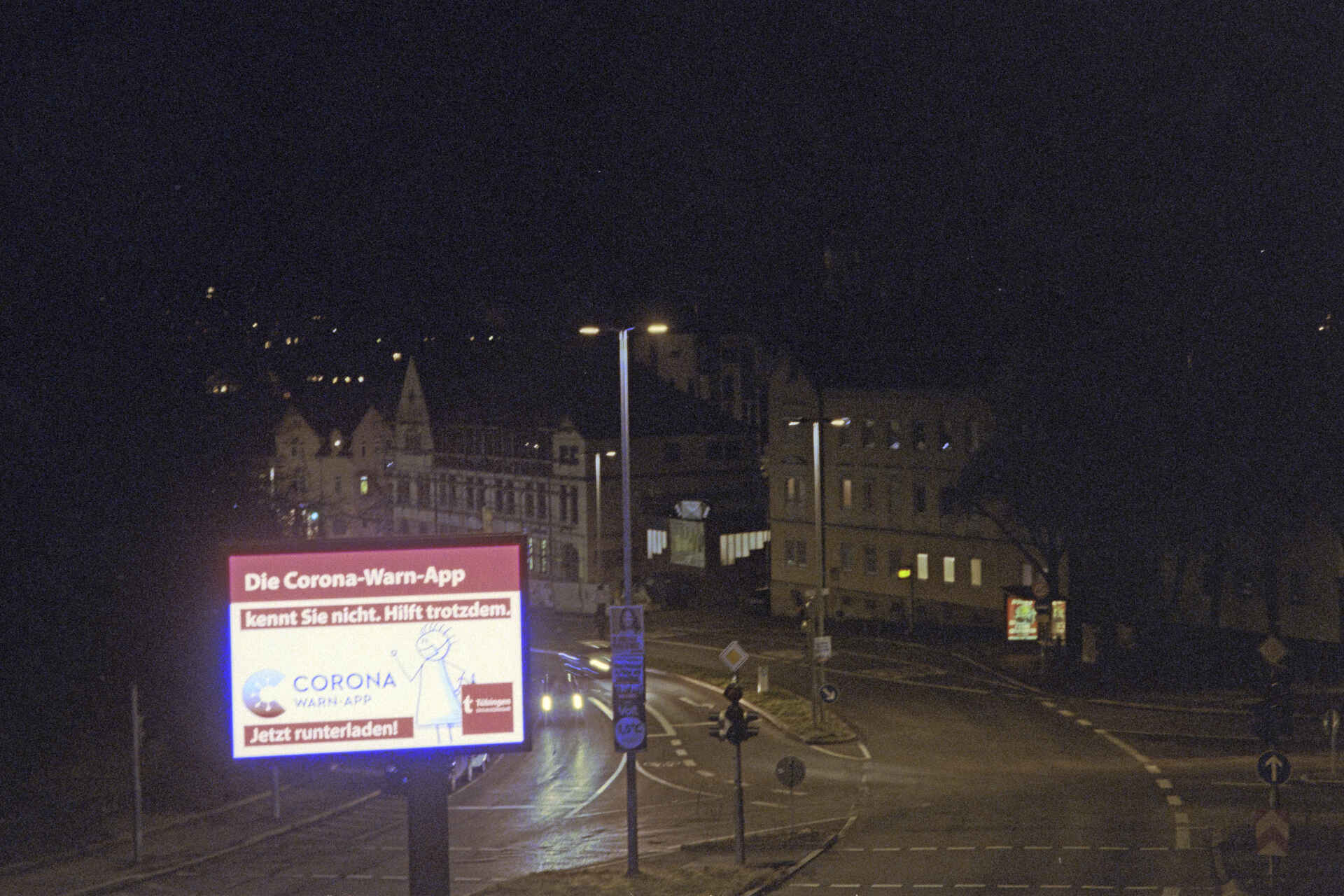 Werbung für die Corona-Warn-App in Tübingen (Foto: Martin Frech, 2/2021) Farbbild (Scan vom Kodak-Ultramax-400-Negativ): Werbung für die Corona-Warn-App, nachts auf einer selbstleuchtenden Werbetafel in Tübingen. (Foto: Martin Frech, 2/2021)