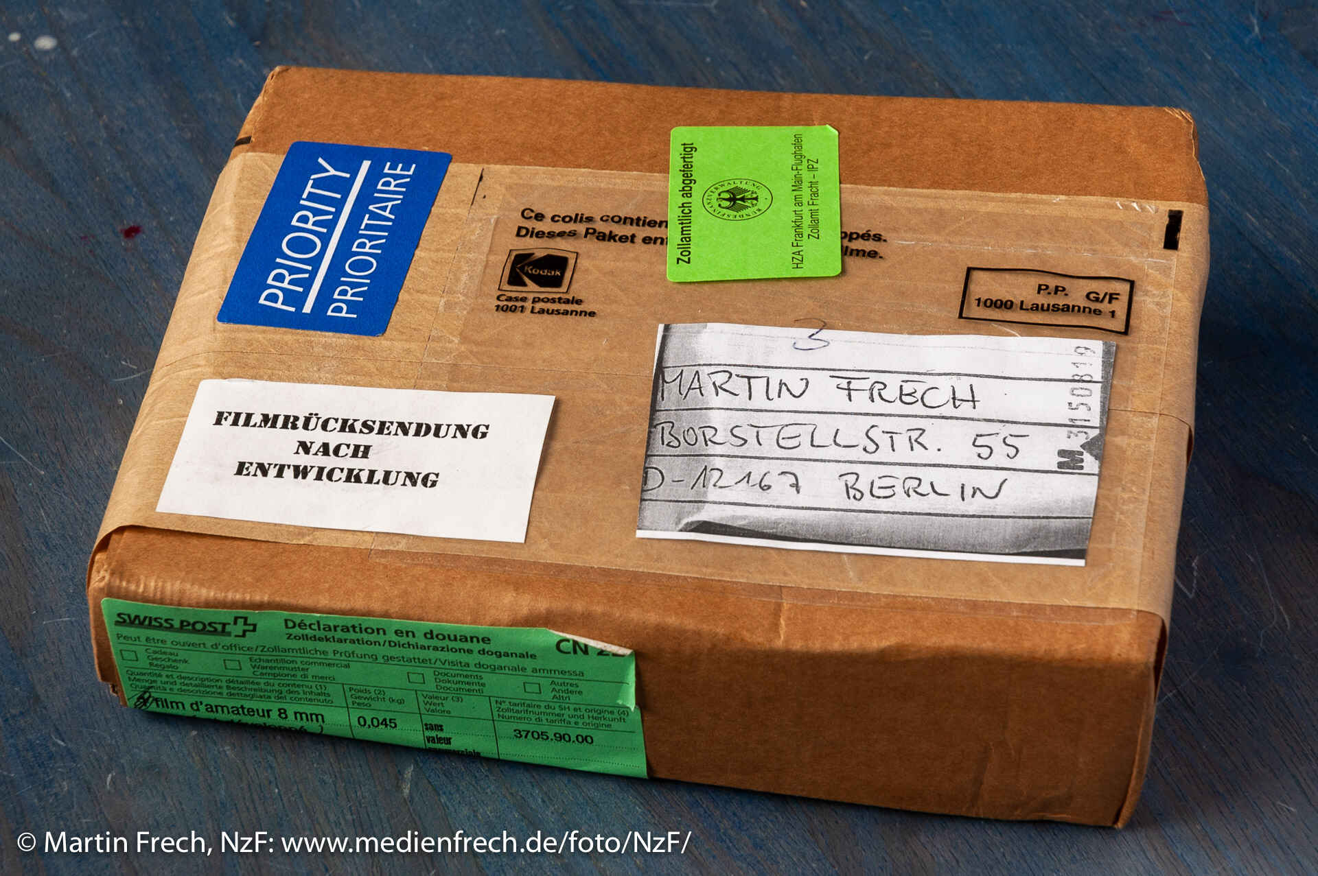 Meine entwickelten Kodachrome-40-Super-8-Filme sind zurück. (Foto: Martin Frech) Farbbild: Ein Paket mit der Aufschrift ›Filmrücksendung nach Entwicklung‹ auf einem Tischchen (Foto: Martin Frech)