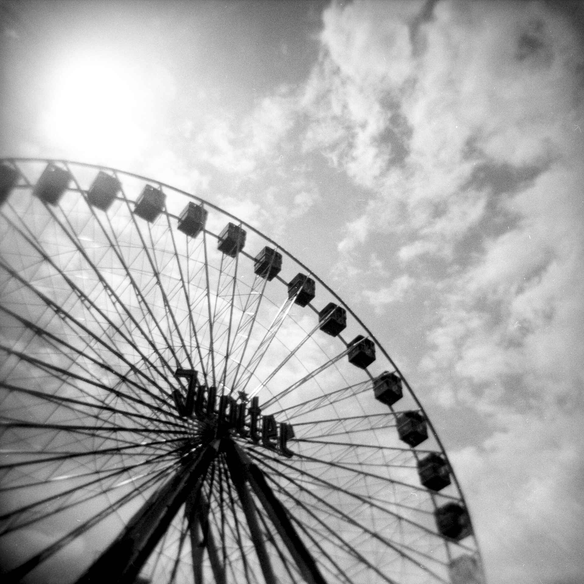 Schwarzweißfoto [Holga]: angeschnittenes Riesenrad in Untersicht. (Foto: Martin Frech, 5/2021)