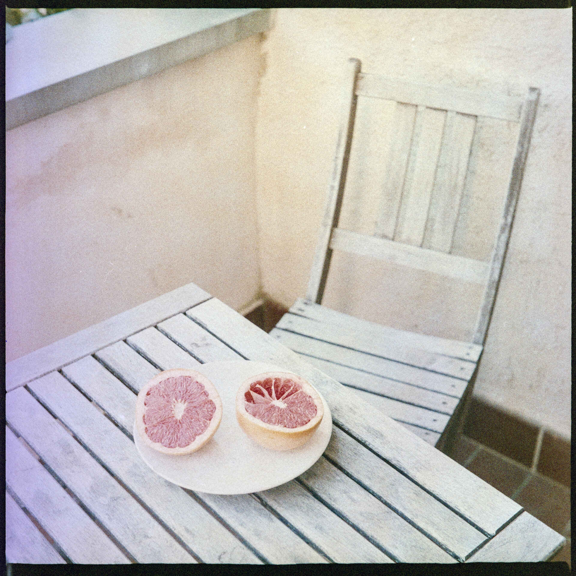 Farbbild (invertiertes Digitalisat des Colornegativs): Eine aufgeschnittene Grapefruit auf dem Teller (Foto: Martin Frech, 7/2026)