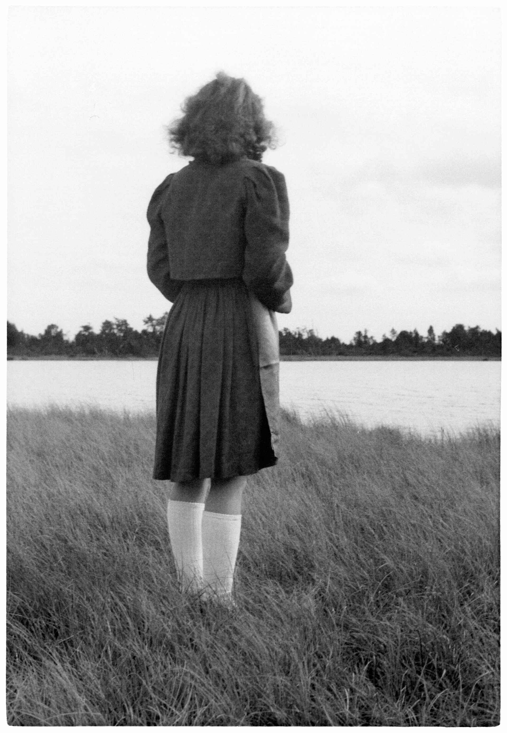am Wasser (Foto: StadtA Rt./Dohm, 9/1946) Schwarzweißfoto: Frau steht mit dem Rücken zur Kamera am Wasser. (Foto: StadtA Rt./Dohm, 9/1946)