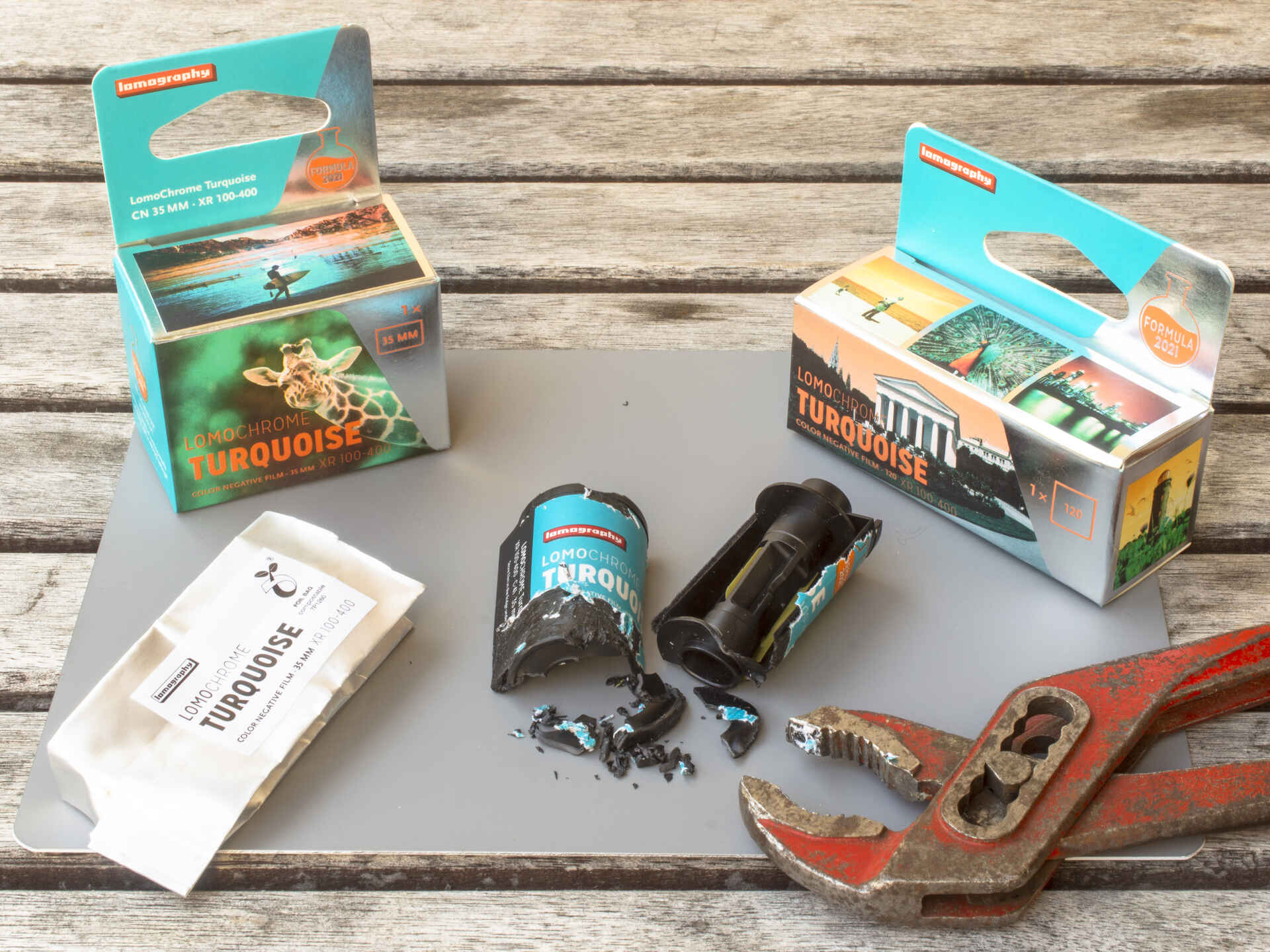 Farbbild (born digital): Filmschachteln des ›LomoChrome Turquoise‹ (Kleinbild- und Rollfilm) und eine aufgebrochene Filmpatrone. (Foto: Martin Frech, 8/2026)