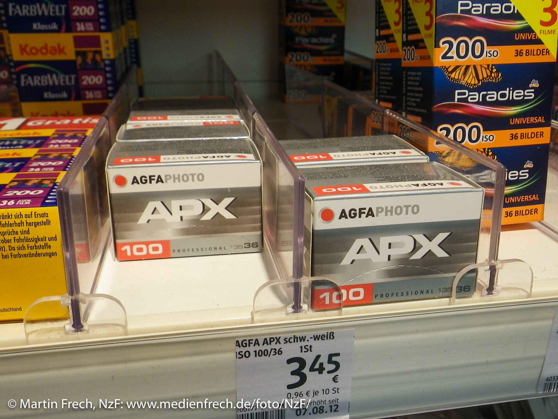 Die letzten echten APX-100-Filme von Agfa im Drogeriemarkt (Foto: Martin Frech, 7/2013) Farbbild: Schachteln mit APX-100-Filmen im Verkaufsregal eines Drogeriemarkts. (Foto: Martin Frech, 7/2013)