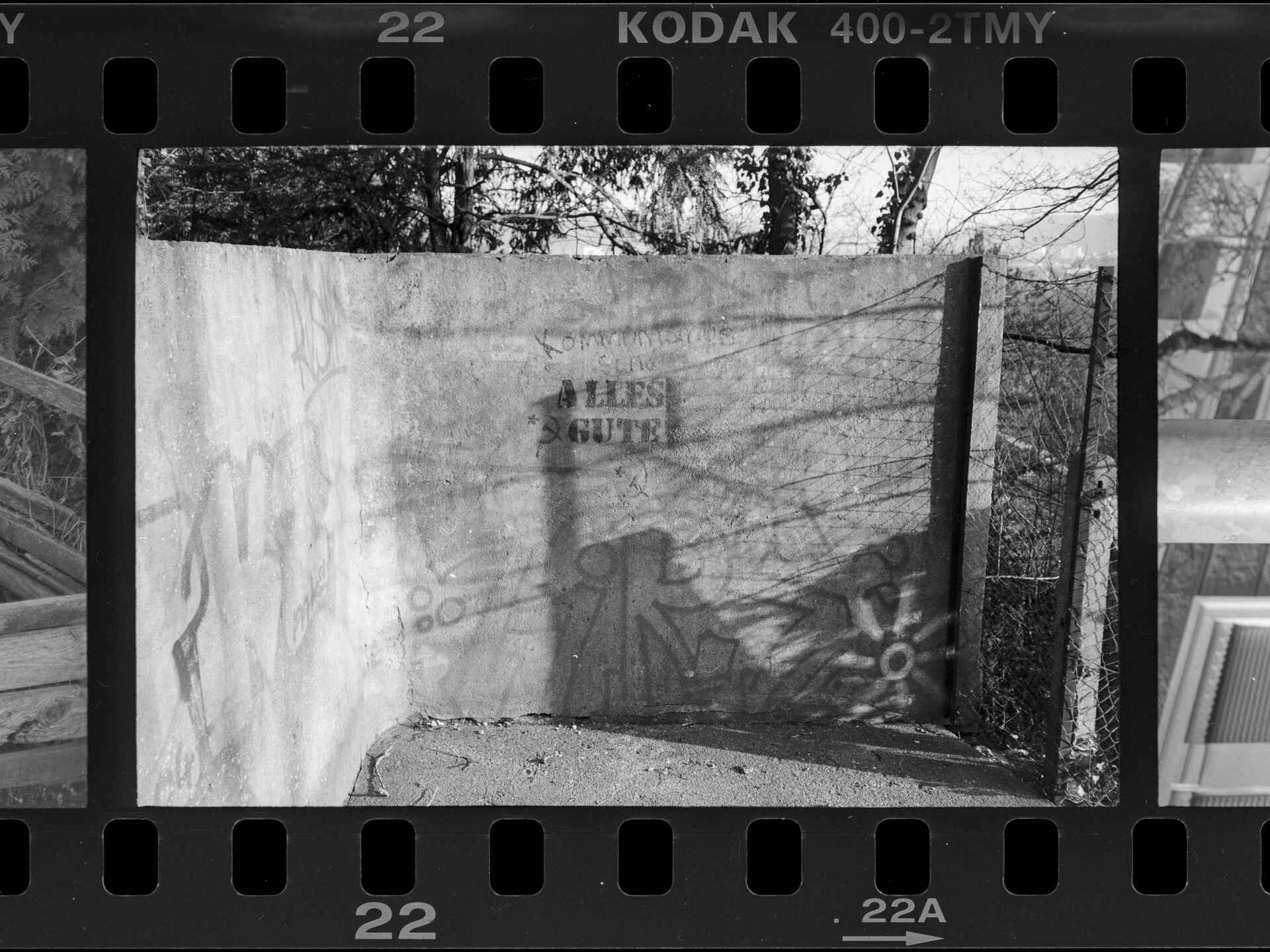 Schwarzweißbild (DSLR-Scan vom Negativ): Stencil ›ALLES GUTE‹ mit dem kommunistischen ☭-Symbol (Hammer und Sichel gekreuzt) an einer Wand an der Schlossbergstaffel in Tübingen. (Foto: Martin Frech, 2016)