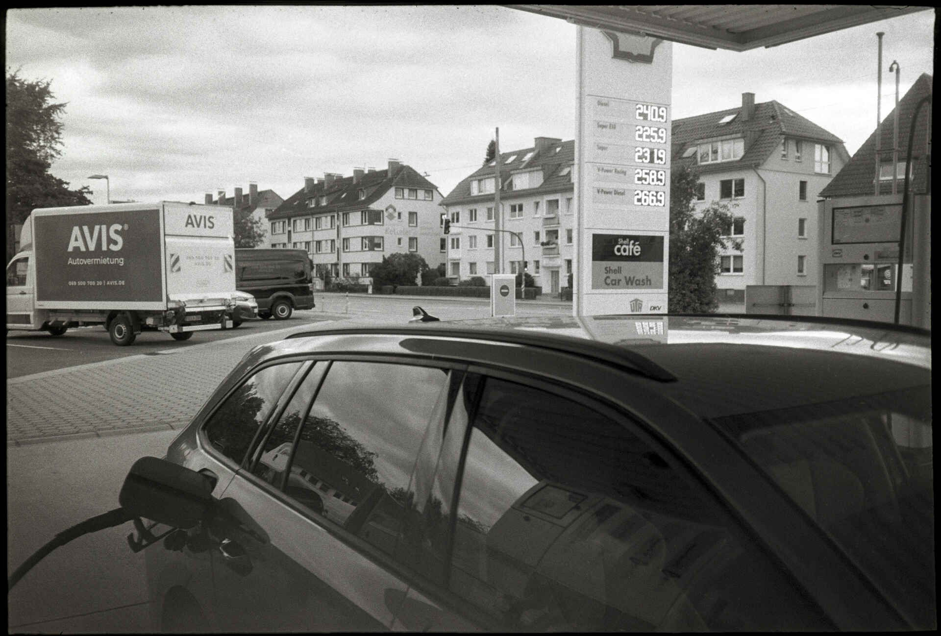 Münster (Foto: Martin Frech, 9/2026) Schwarzweißbild (digitalisiert vom Kodak-Tri-X-Kleinbild-Negativ): Betanken eines Pkw an einer Esso-Tankstelle in Münster; im Hintergrund ist die Preistafel zu sehen.