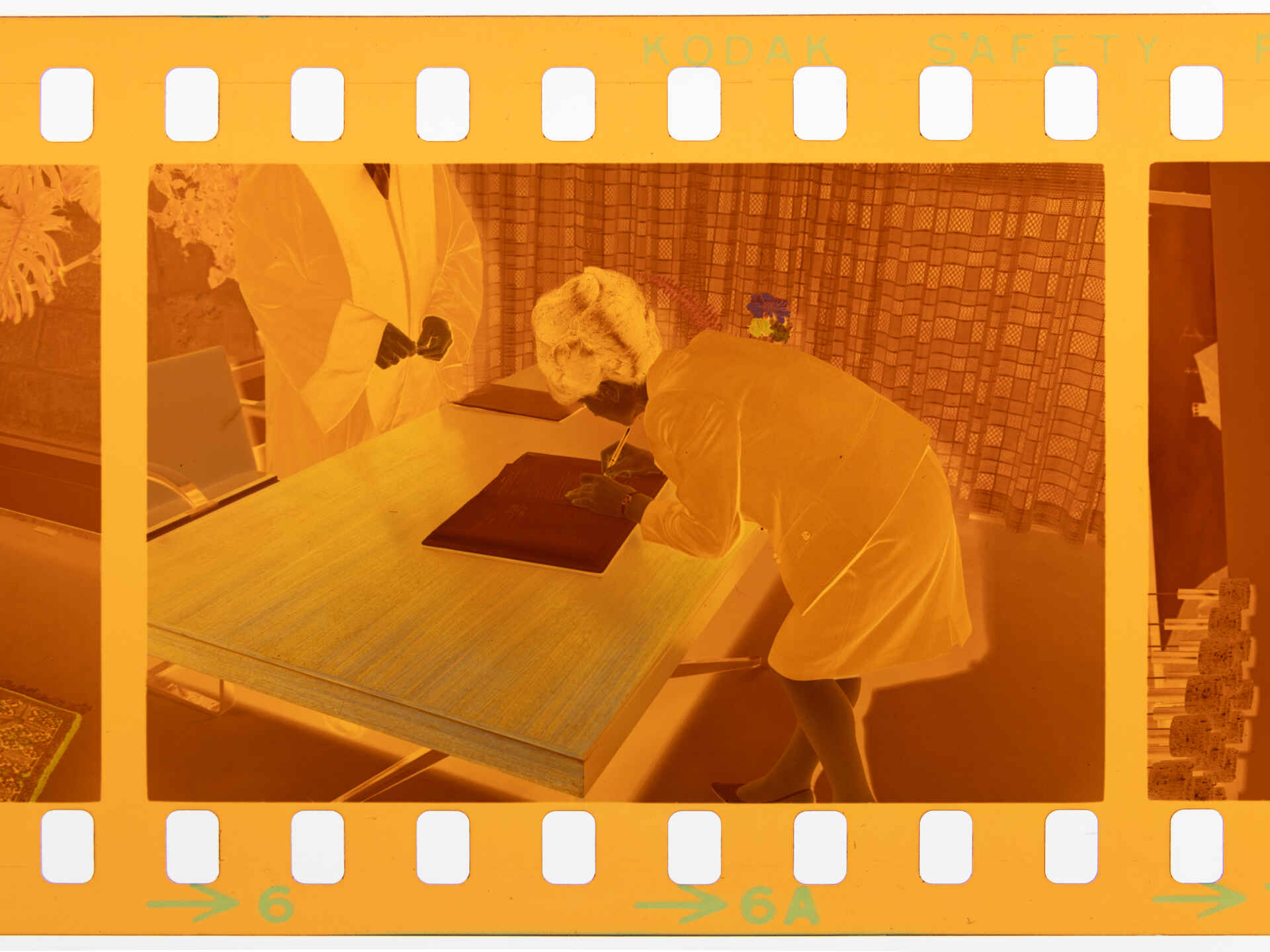 Szene auf dem Standesamt der Stadt Reutlingen (Foto: StadtA Rt./Dohm, 1967) Farbbild (Negativ): Eine Frau unterschreibt eine Urkunde im Beisein einer Amtsperson. (Foto: StadtA Rt./Dohm, 1967)