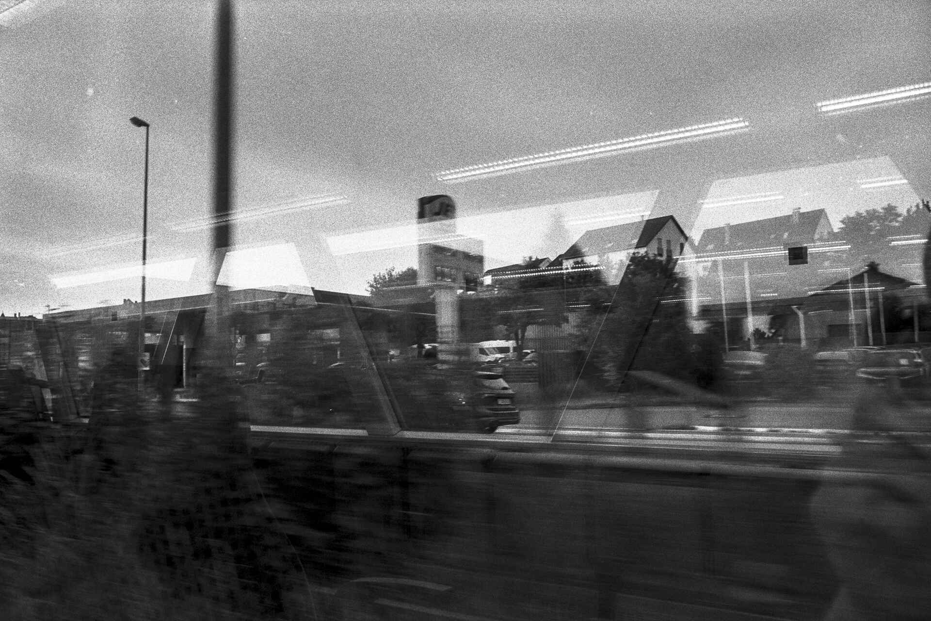 Jet-Tankstelle, Adenauerstraße, Reutlingen Schwarzweißbild (digitalisiert vom HP5-Kleinbild-Negativ): Blick aus dem Fenster eines fahrenden Zugs auf eine Jet-Tankstelle.