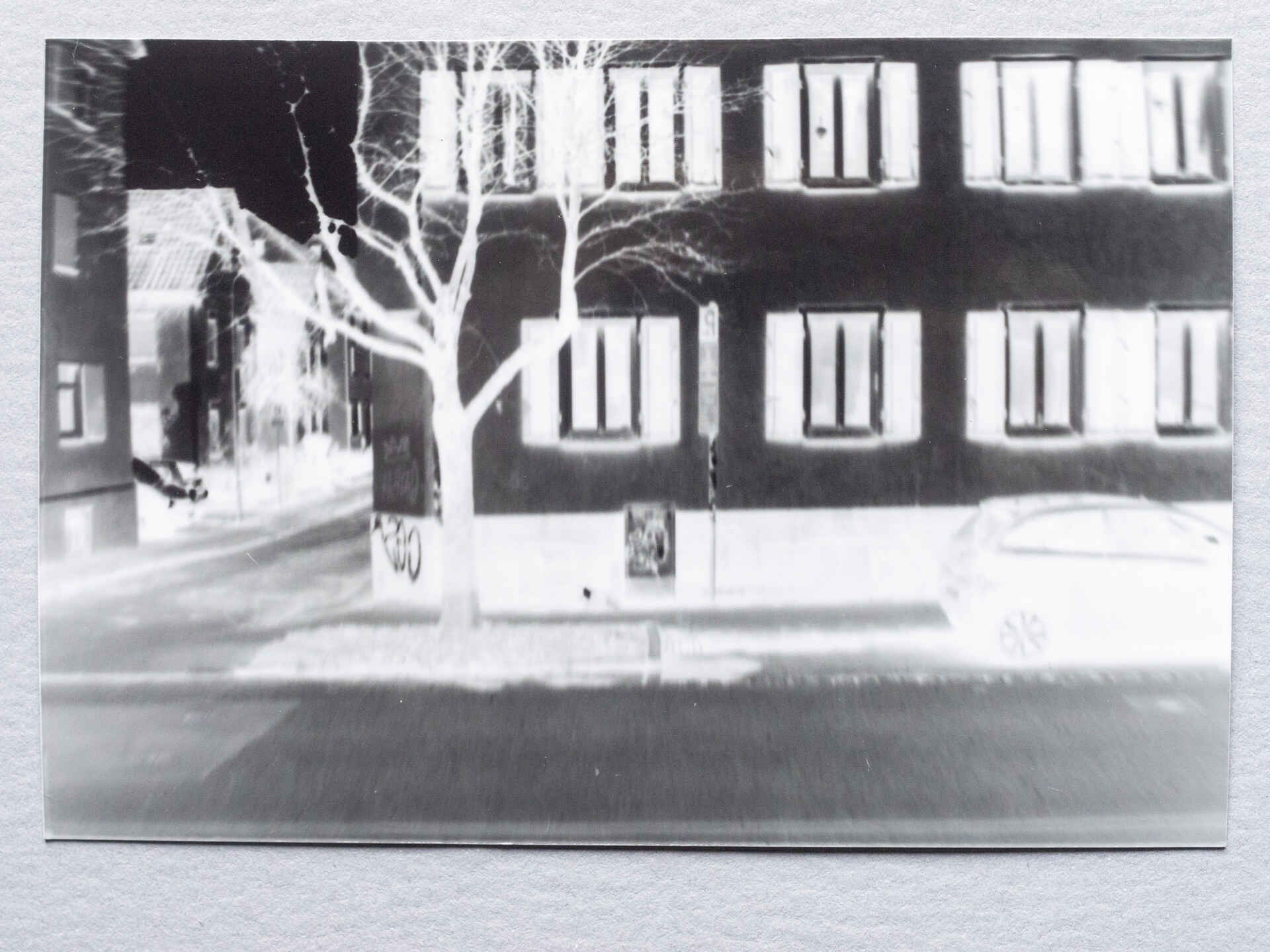 Das Haus gegenüber. (Foto: Martin Frech, 2/2026) Schwarzweißbild (Repro vom original Papiernegativ): Haus an einer Straße. (Foto: Martin Frech, 2/2026)