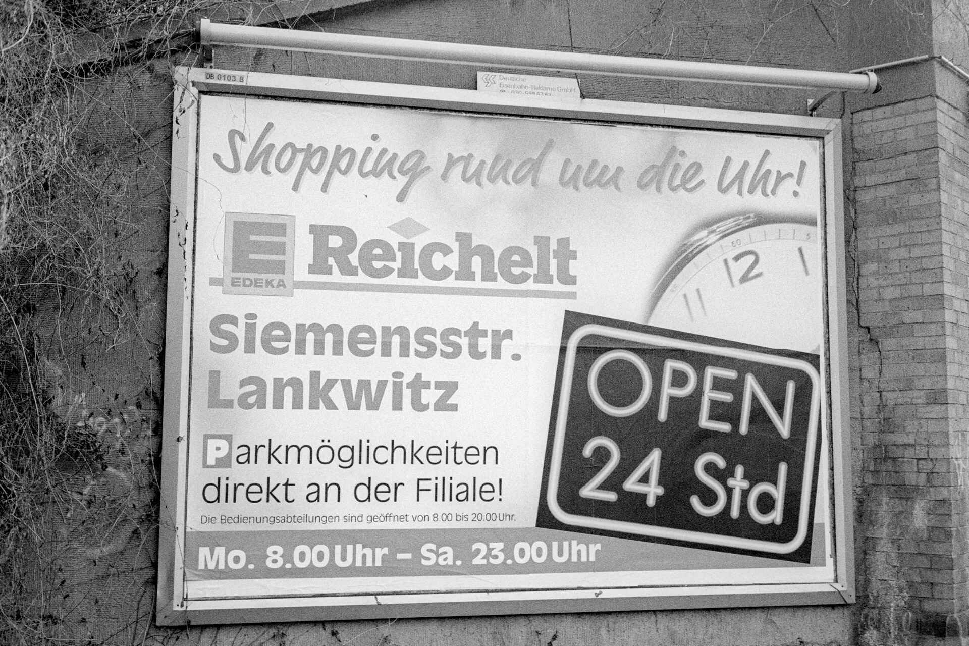 Werbeplakat, Berlin (Foto: Martin Frech, 1/2008) Schwarzweißbild: Werbeplakat für Edeka-Reichelt ›Open 24 Std‹ (Foto: Martin Frech, 1/2008)