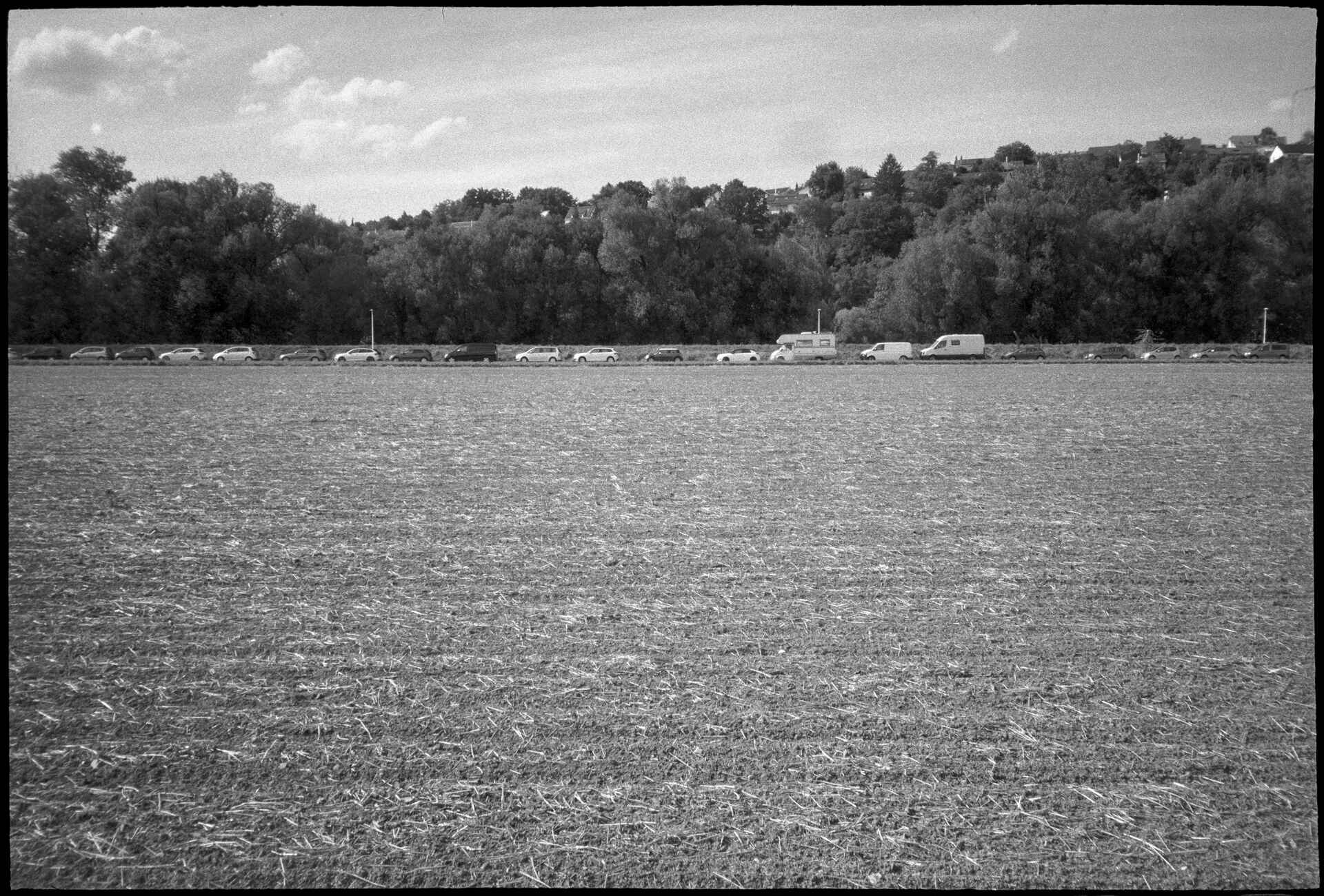 Schwarzweißbild (digitalisiert vom Ilford-Delta-400-Kleinbild-Negativ): Abgeerntetes Feld im Tübingen-Lustnau.